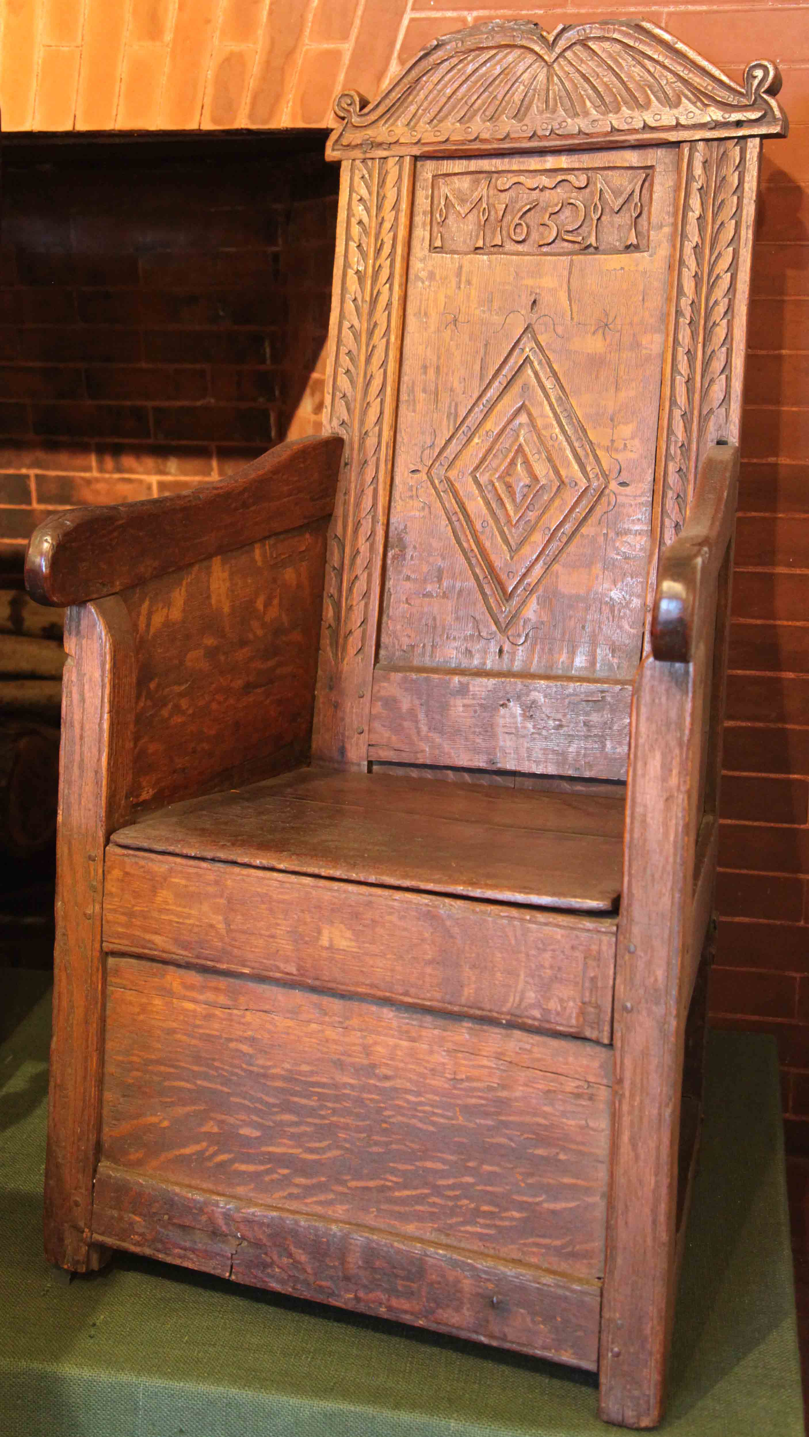 A large wooden chair, marked with M1652M on the back, which originally belonged to Michael Metcalf