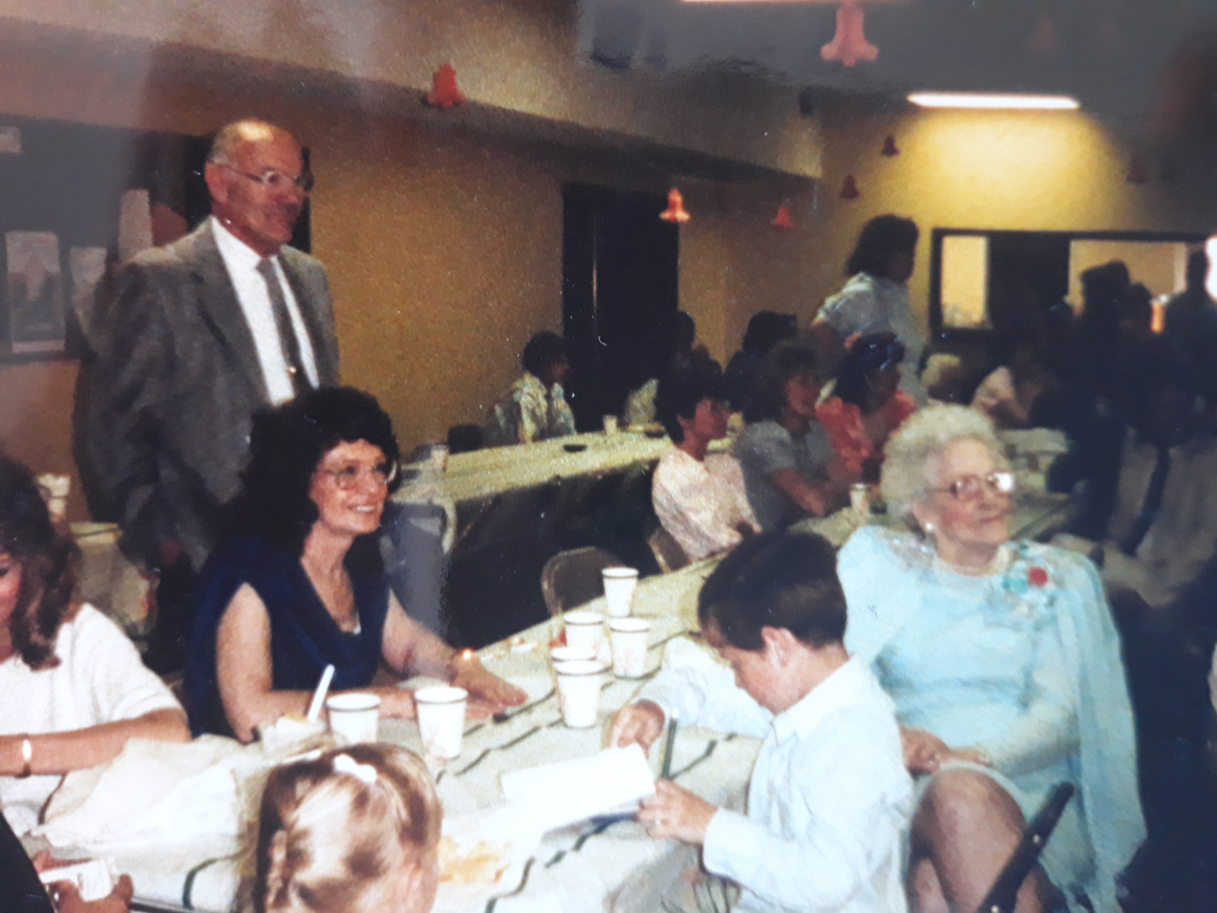 Andy, Naomi, and Grandma Murray at a party with others