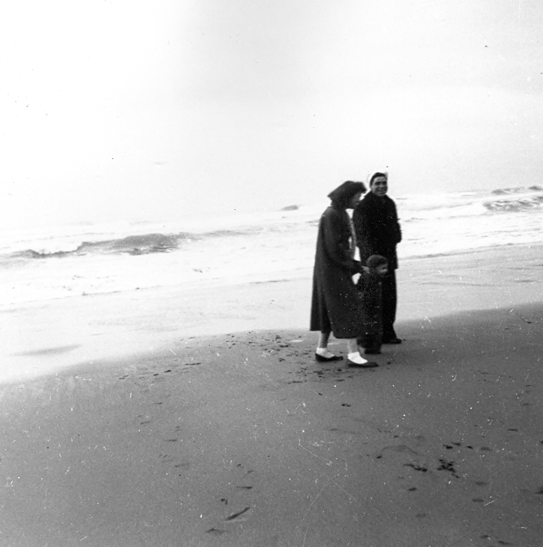 Florence and her son Frank walking with Pete on a beach