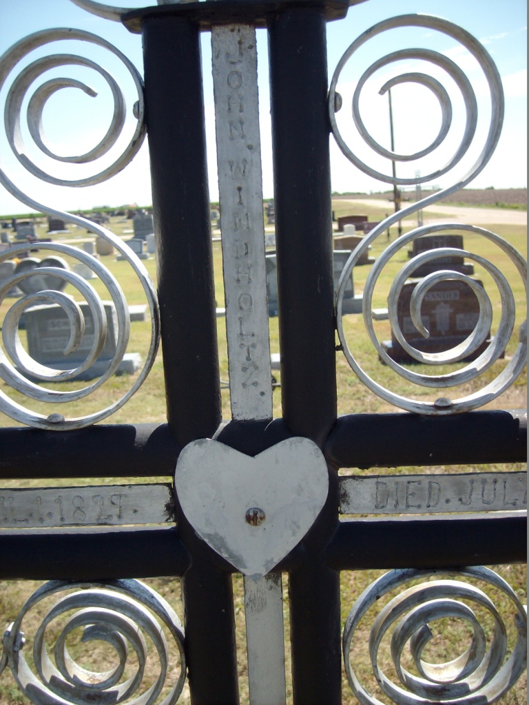 Closeup of top of cross on grave marker of John Windholz